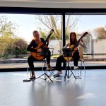 Zwei Musikerinnen spielen Akustikgitarre